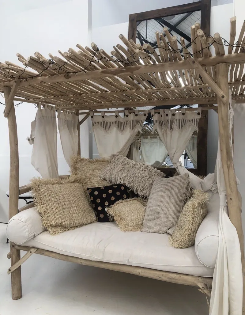 Cama de exterior con estructura de palos de eucalipto y cojines